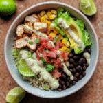 Homemade chicken burrito bowl with cilantro-lime rice, beans, corn, avocado, and pico de gallo.