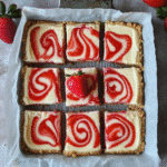 Strawberry cheesecake bars with graham cracker crust and strawberry swirl cut into squares