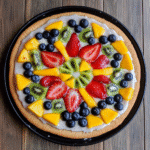 Fruit pizza with a sugar cookie crust and colorful fruit toppings
